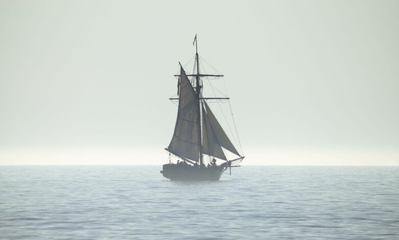 A tranquil silhouette of a sailing ship on a calm sea horizon, evoking peace and adventure.
