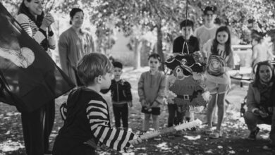 Children at a pirate-themed birthday party outdoors, ready to hit the piñata.