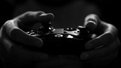 Close-up of hands holding a game controller in a monochrome setting, capturing the essence of gaming.