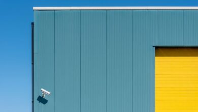 Simple architectural composition with a security camera on a colorful building facade.