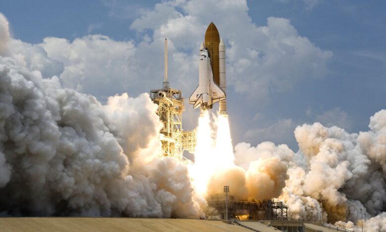 Witness the powerful launch of a space shuttle amidst massive clouds of smoke against a bright sky.