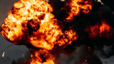 Intense explosion with fiery flames and dark smoke billowing skyward, showcasing dramatic impact.