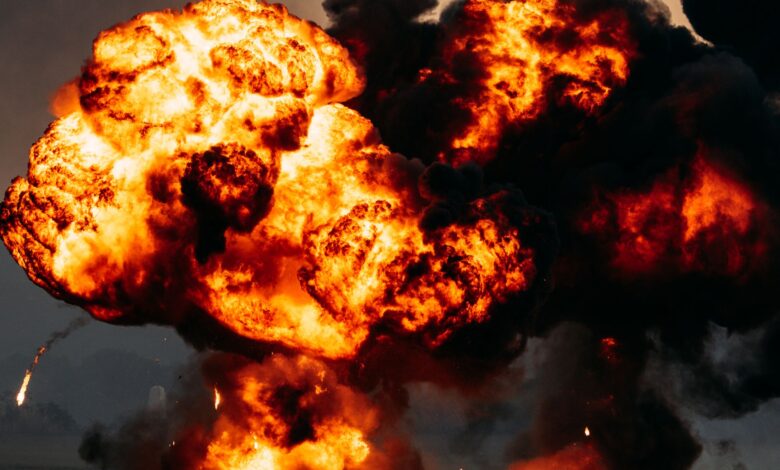 Intense explosion with fiery flames and dark smoke billowing skyward, showcasing dramatic impact.