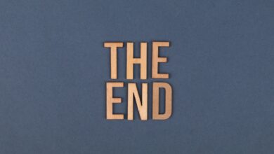 Wooden letters form 'The End' on a plain blue surface, ideal for concluding or finality themes.