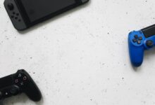 A flat lay of gaming consoles and controllers on a white surface, ideal for tech enthusiasts.
