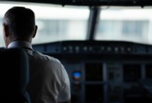 A focused view of an airline pilot in the cockpit, emphasizing responsibility and aviation control.