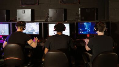 Three men focused on an intense PC gaming session in a modern esports arcade, enjoying teamwork and strategy.