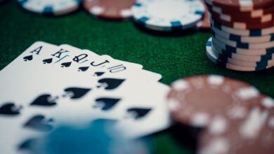 Close-up of a royal flush poker hand surrounded by colorful chips on a green table.