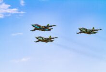 Sukhoi Su-25 aircrafts flying in perfect formation against a clear blue sky.