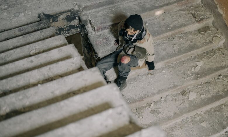Young man in abandoned building, sitting on stairs, in post-apocalyptic setting.