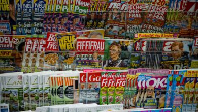 A vibrant display of magazines in a newsstand, showcasing various colorful covers and headlines.