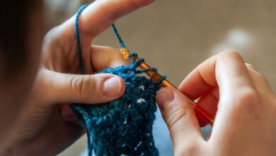 Detailed image of hands crocheting a blue yarn piece with a crochet hook. Ideal for crafting themes.