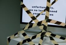 A computer screen taped and displaying a termination message, symbolizing unemployment.