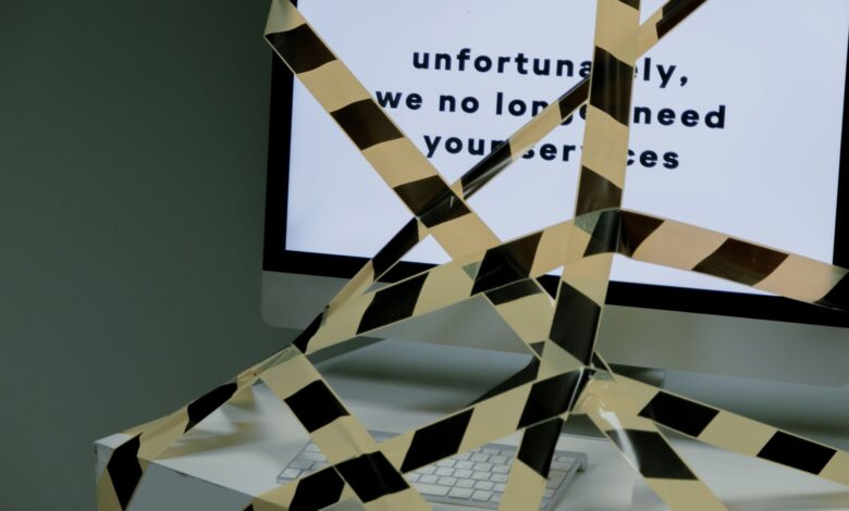 A computer screen taped and displaying a termination message, symbolizing unemployment.