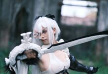 Captivating shot of a cosplayer in action with a sword amidst ancient Vietnamese ruins.