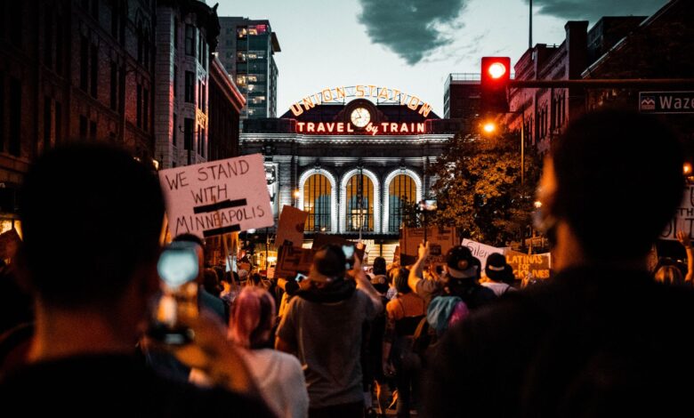 A protest at Denver's Union Station with signs supporting Minneapolis, captured at night.