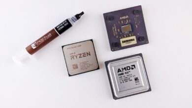 High-angle view of AMD processors and Noctua thermal paste on a white surface.