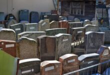Diverse gravestones on display outdoors, showcasing different designs and materials ready for selection.