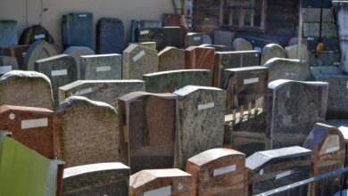 Diverse gravestones on display outdoors, showcasing different designs and materials ready for selection.