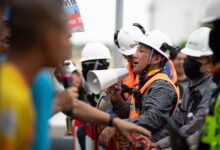 Construction workers in a heated protest with security present. Safety and communication emphasized.