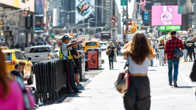 Vibrant urban scene in Times Square with pedestrians and traffic on a sunny day.