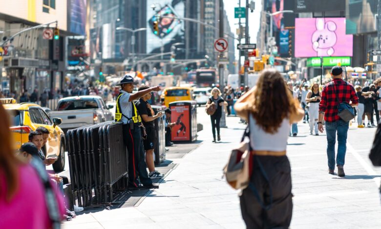 Vibrant urban scene in Times Square with pedestrians and traffic on a sunny day.