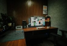 Cozy indoor workspace featuring dual monitors, speakers, and mood lighting.