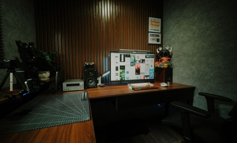 Cozy indoor workspace featuring dual monitors, speakers, and mood lighting.