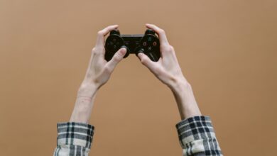 Close-up of hands holding a game controller against a brown background, perfect for gaming themes.