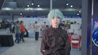 Cosplayer with icy blue wig poses at a vibrant convention center event.