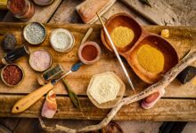 Explore a variety of natural pigments and tools on a rustic wooden surface for artistic projects.