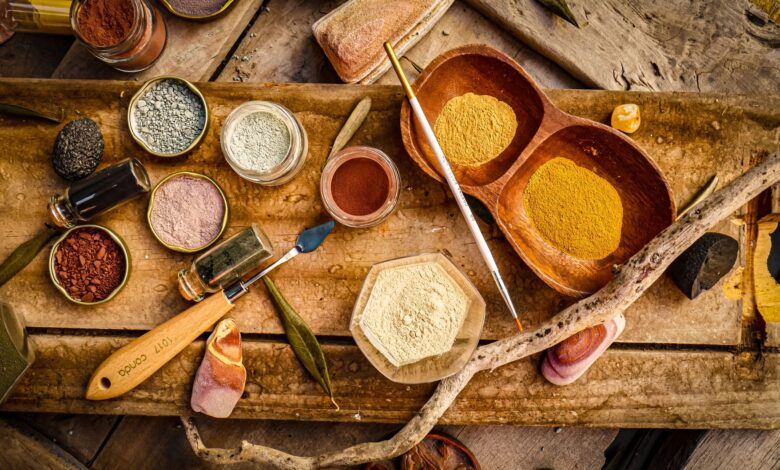 Explore a variety of natural pigments and tools on a rustic wooden surface for artistic projects.