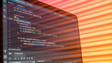 Colorful abstract reflection on screen showing programming code in development environment.