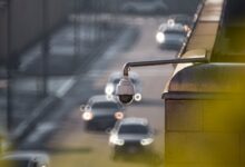 CCTV camera monitoring city traffic on a busy road with blurred vehicles in the background.
