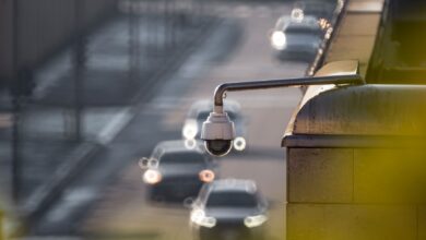 CCTV camera monitoring city traffic on a busy road with blurred vehicles in the background.