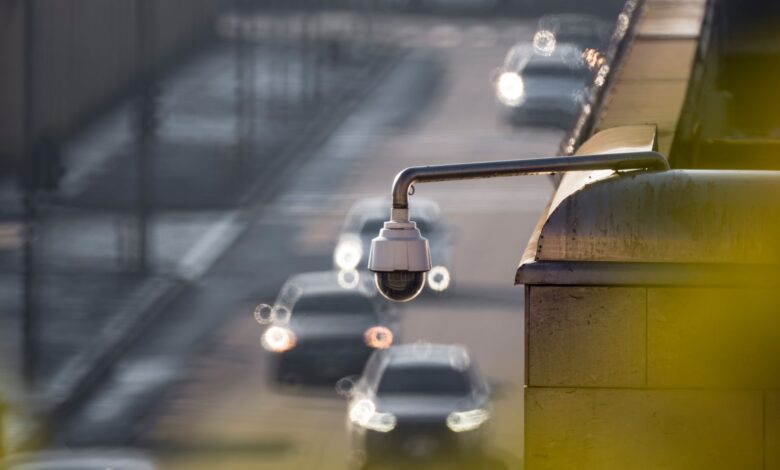 CCTV camera monitoring city traffic on a busy road with blurred vehicles in the background.
