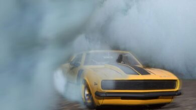 1969 Camaro drifting on pavement with smoke engulfing the car, showcasing its power.