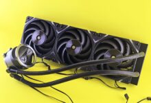 High-performance CPU cooler with a triple fan radiator on yellow background, ideal for PC upgrades.