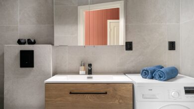 Contemporary bathroom featuring a sleek wooden vanity, washing machine, and modern fixtures.