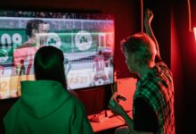 Two friends enjoying an exhilarating video game session indoors, captured with vibrant lighting.