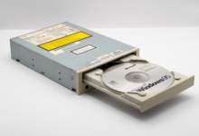 Vintage CD-ROM drive with Microsoft Windows 95 disc, iconic retro tech.