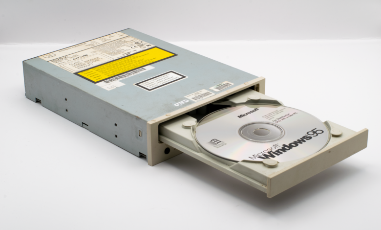 Vintage CD-ROM drive with Microsoft Windows 95 disc, iconic retro tech.