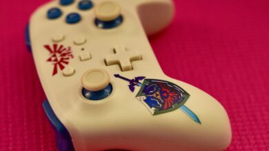 Close-up of a gaming controller with a unique design on a vibrant pink surface.
