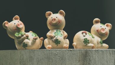Set of three ceramic pig figurines adorned with clover, symbolizing luck and prosperity.