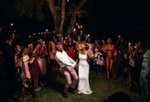 A vibrant wedding party celebrating under lights in Nigeria.