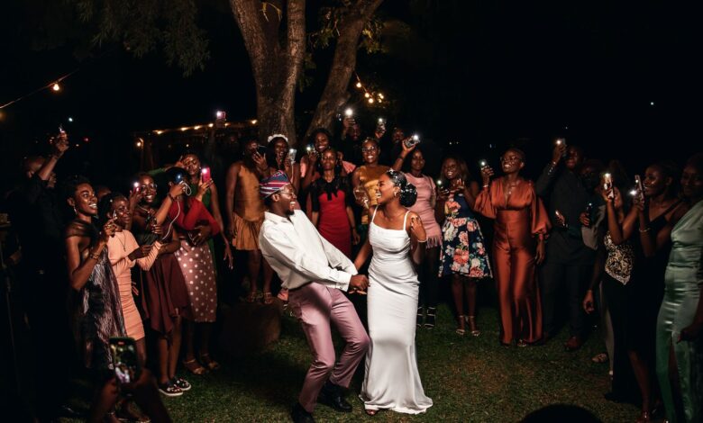 A vibrant wedding party celebrating under lights in Nigeria.
