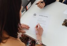 A person signing a divorce decree document with focus on hands and paper.