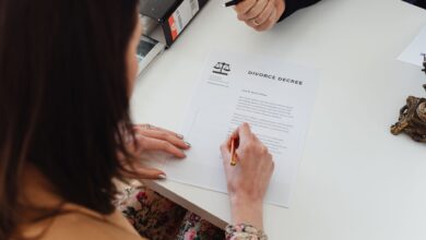 A person signing a divorce decree document with focus on hands and paper.
