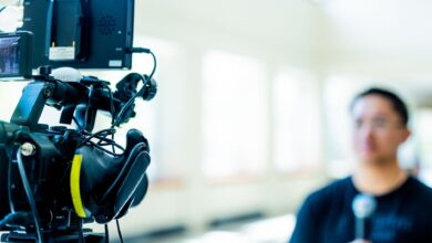 Professional video camera setup focusing on an interview with blurred subject in the background.