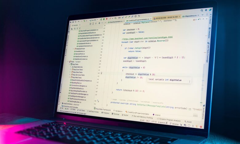 A laptop screen showing a code editor with visible programming code in a dimly lit environment.